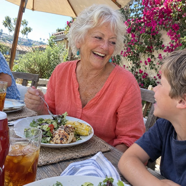 Woman in her sixties at a grandchild’s table, plate in front of her, not getting up