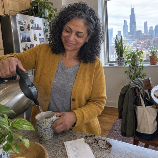 Woman in her late fifties in a kitchen at 3 p.m., kettle on, not lying down